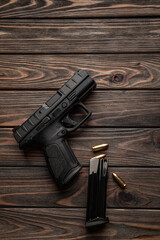 Wall Mural - Pistol and cartridges for it on a wooden back. A short-barreled weapon for self-defense.