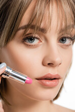 Close Up View Of Young Woman With Bangs Holding Pink Lipstick Isolated On White