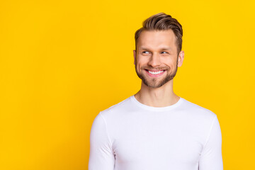 Poster - Portrait of glad funky person toothy smile look interested empty space isolated on yellow color background