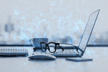 Wall Mural - Close up of office desktop with supplies, glasses, coffee cup, laptop and blue polygonal mesh on blurry city view background. Technology, security and web hacking concept. Double exposure.