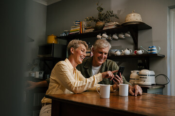 Caucasian senior couple drinking coffee in kitchen