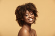 Leinwandbild Motiv Portrait of African American woman with a clean healthy skin on a beige isolated background. Smiling beautiful black female model.