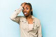 Young african american woman isolated on blue background forgetting something, slapping forehead with palm and closing eyes.