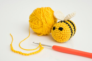 Yellow crocheted bees and thread with crochet. DIY home made hand made baby rattle toy safe for toddlers.