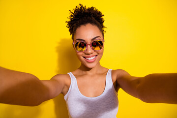 Wall Mural - Portrait of funky positive girl take selfie recording video toothy smile isolated on yellow color background