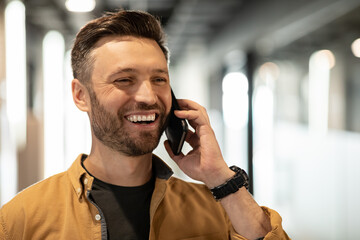 Canvas Print - Cheerful Businessman Talking On Cellphone Looking Aside Standing In Office