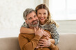 © Prostock-studio - Loving Middle Aged Couple Embracing Sitting On Sofa At Home