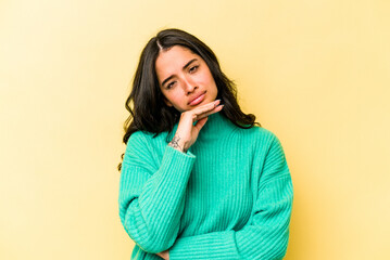 Young hispanic woman isolated on yellow background tired of a repetitive task.