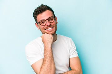 Young caucasian man isolated on blue background smiling happy and confident, touching chin with hand.