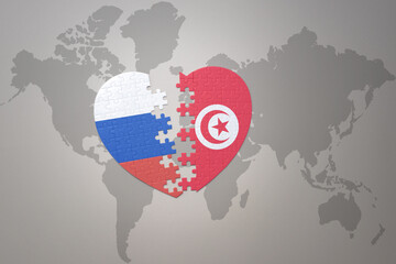 puzzle heart with the national flag of russia and tunisia on a world map background. Concept.