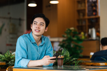 Asian man sitting and drinking coffee