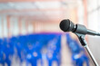 © jittawit.21 - Microphone soft focus on blur abstract background lecture hall, seminar meeting room in business event, educational academic classroom training course.