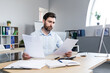 © Liubomir - Thinking businessman working with documents in the office, man reviewing financial reports