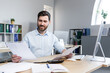 © Liubomir - Happy businessman at paper work, examining financial documents, man at work working in the office