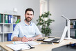 © Liubomir - Portrait of successful businessman, man smiling and working on laptop in modern bright office