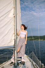 Calm Young Lady Admiring Nature While Standing On Sailboat