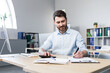 © Liubomir - Portrait of a young man. Accountant, economist, financier. Counts on a calculator, sits at a desk at the computer, works with documents