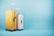 Baggage and travel concept with yellow and white suitcases on blue blank backdrop with copyspace for your logo or text. 3D rendering, mock up