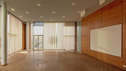 Empty director`s office with parquet, wooden wall and big windows in the former city library of Ghent, Belgium 