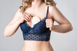 © staras - Beautiful young woman in blue push up bra with inserts on gray background