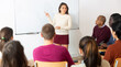 © JackF - Group of students attentively listening to lecture of female teacher in classroom