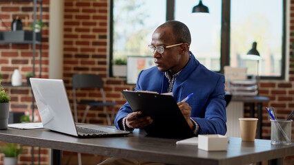 Wall Mural - project manager analyzing statistics plan with application report on laptop at office desk. company 