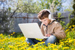 © ulza - homeschooling, distant learning. Chatting with Friends, Studying School Homework. preteen boy in headphones using a laptop, connecting to the Internet outdoors at yard.
