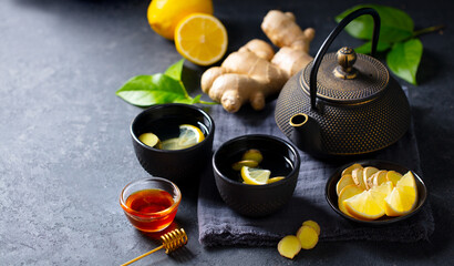 Wall Mural - Ginger tea with lemon. Grey background. Healthy immunity boost hot drink. Close up. Copy space.