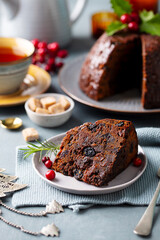 Wall Mural - Christmas pudding, fruit cake with cup of tea. Traditional festive dessert. Grey background. Close up.