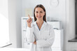 © Syda Productions - medicine, healthcare and profession concept - smiling female doctor pointing finger up at hospital
