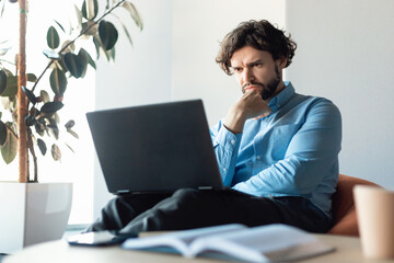 Canvas Print - Focused business man using laptop sitting on beanbag chair