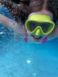 Smiling child in goggles swim, dive in the pool with fun - jump deep down underwater. Healthy lifestyle, people water sport activity on summers. 