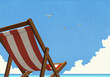 © fStop - Seagulls flying in summer blue sky over striped beach chair
