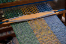 Blue, Green And Orange Thread Forming Pattern On Loom
