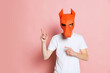 Creative portrait of young man in white t-shirt with cardboard animal mask on his head isolated on pink background. Concept of art, fashion, theater, funny meme emotions.