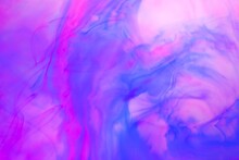 Shallow Depth Of Field Shot Of Swirling Pink And Blue Ink In Water - Soft Flowing Abstract And Soothing Backdrop