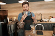 © Yaroslav Astakhov - Handsome barista enjoys the great aroma of coffee beans at his workplace