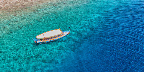 Poster - Maldivian exotic diving boat  in amazing ocean lagoon over coral ref. Snorkel and outdoor adventure, activity travel landscape concept. Aerial sea view, tranquil nature, luxury travel vacation scenic