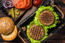 Cooking Plant Based Meatless Burgers With Vegetarian Meat Free Roasted Cutlets, Patties, Tomato And Onion In A Wooden Serving Tray. Wooden Background. Top View