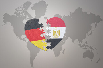 Wall Mural - puzzle heart with the national flag of egypt and germany on a world map background. Concept.