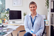 © Monkey Business - Portrait Of Smiling Female Doctor Or GP Sitting At Desk In Office