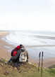 © Caia Image - Affectionate hiker couple hugging on cliff with ocean beach view
