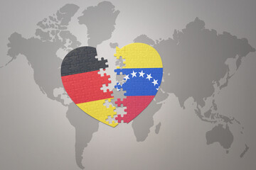 puzzle heart with the national flag of venezuela and germany on a world map background. Concept.