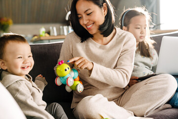 Wall Mural - Happy mother smiling while spending time with her children