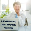 Portrait of smiling asian young businessman with learning at work week text on laptop in office