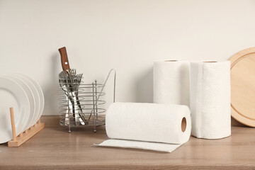 Wall Mural - Many rolls of white paper towels and other kitchen stuff on wooden countertop near light wall