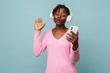 African American Woman Smiling While Using Cellphone And Headphones