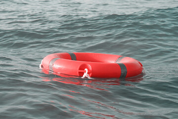 Wall Mural - Life ring in ocean. Red lifebuoy in sea. Life ring floating in water. Red life preserver in see