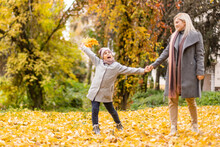Mother And Daughter In Autumn Yellow Park