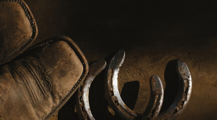 Sticker - Western lifestyle with cowboy boots and horseshoes on old wood retro rustic background.